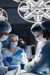 Stitching after a complex and bloody surgery. Teamwork, medical team success, professional...