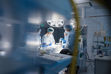 Blurred shot of group of professional surgeons at work in operating room. Emergency case, surgery,...