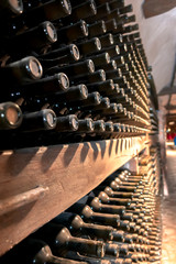 The neck of a bottle of wine in a wine cellar.