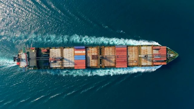 Aerial top view container ship driving on the sea for logistic import export or transportation.
