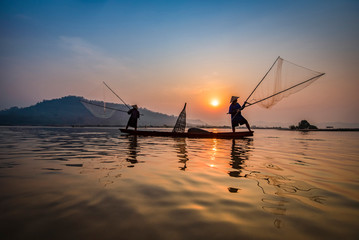 Fisherman on boat river sunset Asia fisherman net using on wooden boat casting net sunset or...