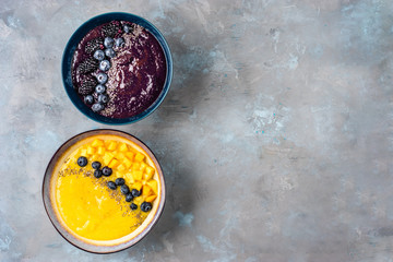 Top view of two plates with yellow and violet smoothies