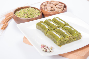 wrapping turkish baklava on platter with pistachio