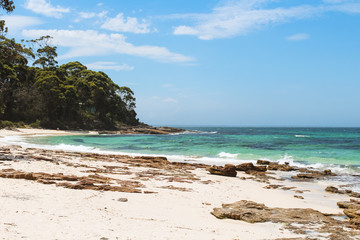 Rock formations in front of a forest at Hyams Beach - the world's whitest beach - at Jervis Bay on a beautiful summer day with azure water (Jervis Bay, Australia)