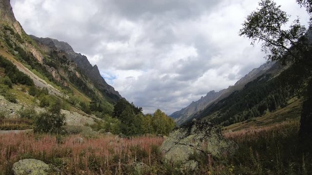 Evening time-lapse in the mountains of Dombai in the North Caucasus before the rain. Gorge with middle forest