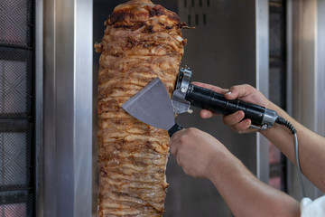 Cocinero partiendo carne de kebab para servir