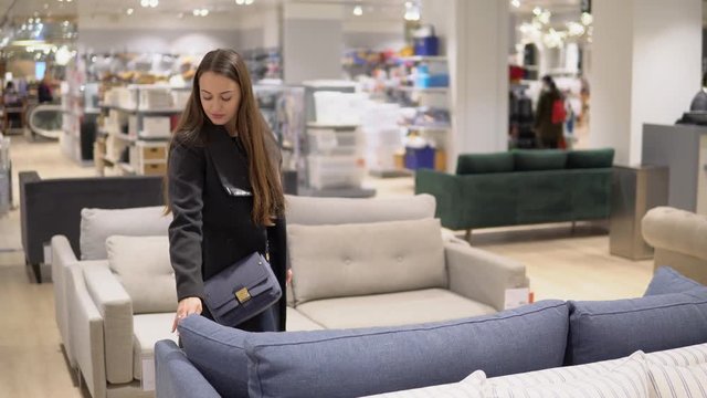 4k shot of a Customer woman buying new furniture - sofa or couch in a store supermarket mall store