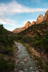 Rocks in the Virgin River, with towering cliffs above, Zion National Park, UT