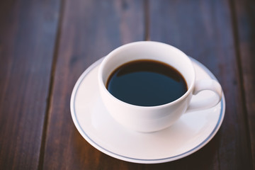 Cup of black coffee on wooden table, hot drink