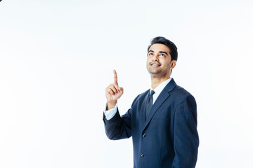 Portrait of a handsome man in business suit and tie pointing and looking up, isolated on white studio background