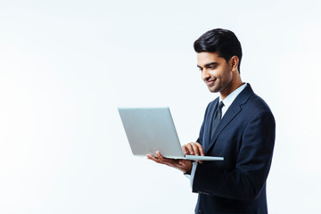 Portrait of a confident young man entrepreneur in business suit working on a laptop,  isolated on white background