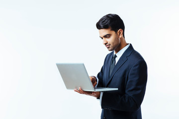 Portrait of a confident young man entrepreneur in business suit working on a laptop,  isolated on white background