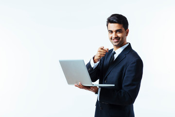 Portrait of a confident young man entrepreneur in business suit holding a laptop and pointing at...