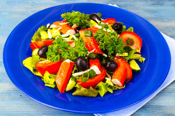 Vegetable salad with olives and crab sticks