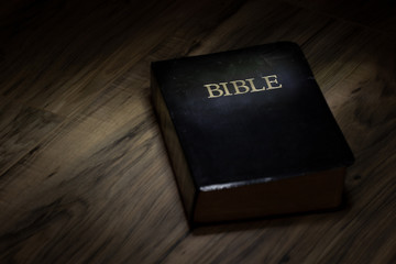 Dramatic lighting on Holy Bible, text space on side of bible great use a background.