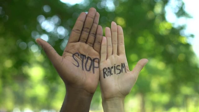 Interracial people hands appearing with stop racism phrase, discrimination