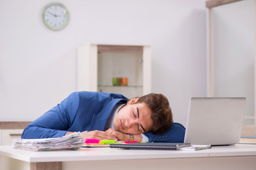 Young attractive businessman working in the office  