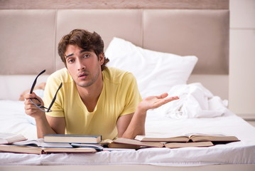 Obraz premium Young student studying in bed for exams