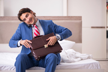 Fototapeta premium Young employee working at home sitting on the bed 