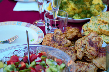 Festive table in the fresh air. On the table kebabs, vegetable salad, boiled potatoes with green dill, olives. Country style. Day of rest. Festive background. Gourmet food