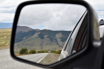 vista de la montagna y cielo nublado en el espejo retrovisor