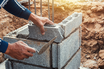 worker installing bricks in construction site