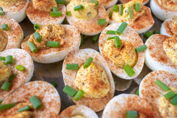 Group of Deviled Eggs with paprika and green onions flat lay