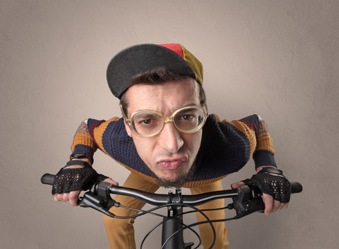 Nerd young foolish biker on a bike with oldschool outfit