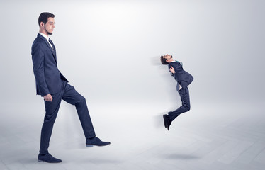 Fototapeta premium Small young man fired by his bos from his workplace with suitcase on his hand 