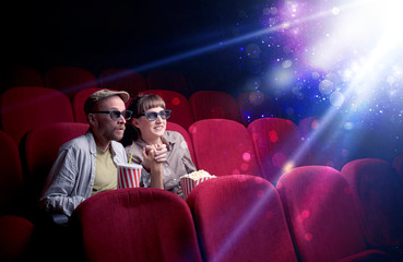 Obraz premium Romantic couple cuddling and watching the miraculous part of the film