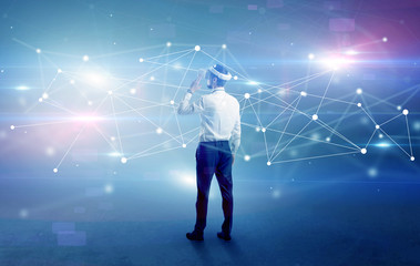 Young businessman standing with vj glasses and checking life-sized connectivity project
