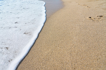  White foam on a sandy beach. Copy space.
