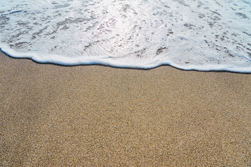  White foam on a sandy beach. Copy space.