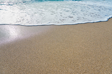  White foam on a sandy beach. Copy space.