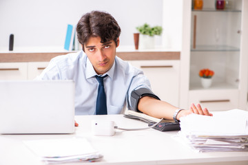 Man under stress measuring his blood pressure