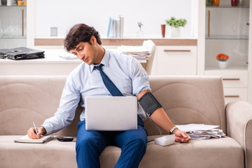 Man under stress measuring his blood pressure