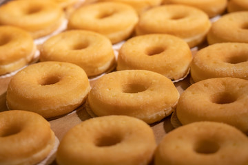 a lot of donut on tray in supermarket