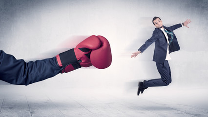 Huge Boxing Gloves punches innocent businessman concept
