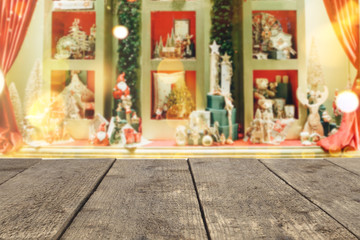 Fototapeta na wymiar Wooden table top on the background of a blurred storefront decorated in Christmas festive style - can be used to montage or showcase your products