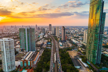Sunset over the city building with transport road aerial view