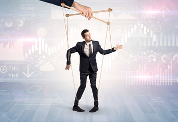 Puppet businessman controlled by another hand with financial concept
