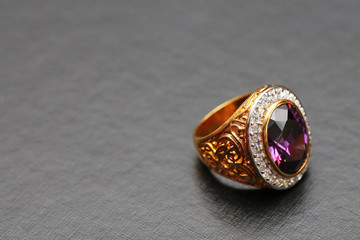 Purple gem stone on gold ring with diamond
