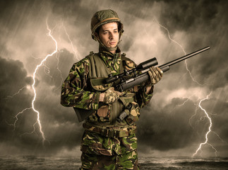 Armed soldier standing in rainy obscure weather
