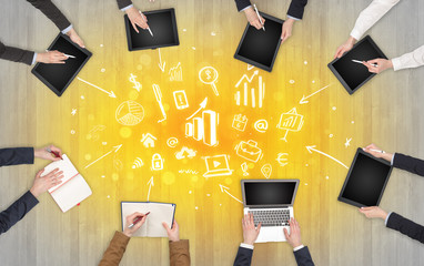 Group of people with devices in hands making reports together on laptop, tablet, notebook
