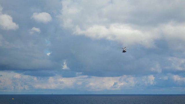 Helicopter heading and landing on an offshore oil rig , service travel to oil and gas platform and drilling rig in offshore locations