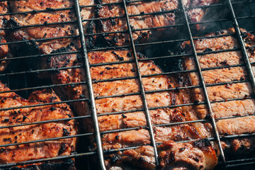 pork meat is cooked on the coals of the fire on the grill barbecue