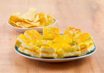 Paneer Burfi or Paneer Kesar Burfi is a Traditional Indian Mithai or Sweet Dish Prepared From Freshly Made Paneer, Mawa, Milk or Cottage Cheese on Wooden Background