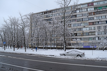 View of the asphalt and the car near the house in the winter city.