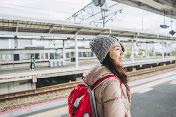 駅のホームを歩く女性