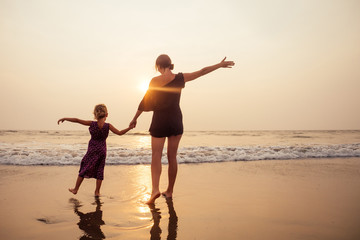 happy family at the beach. mother hugging child daughter and fly tourism with children